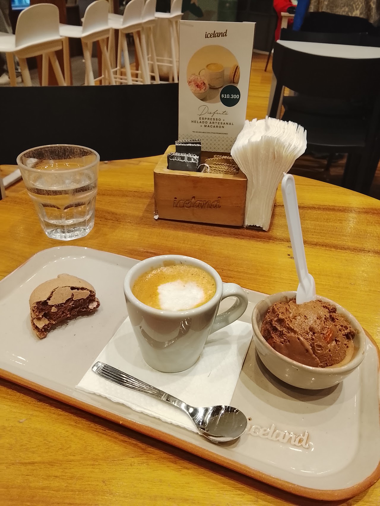 Café latte art servido en una taza de cerámica rústica sobre mesa de madera